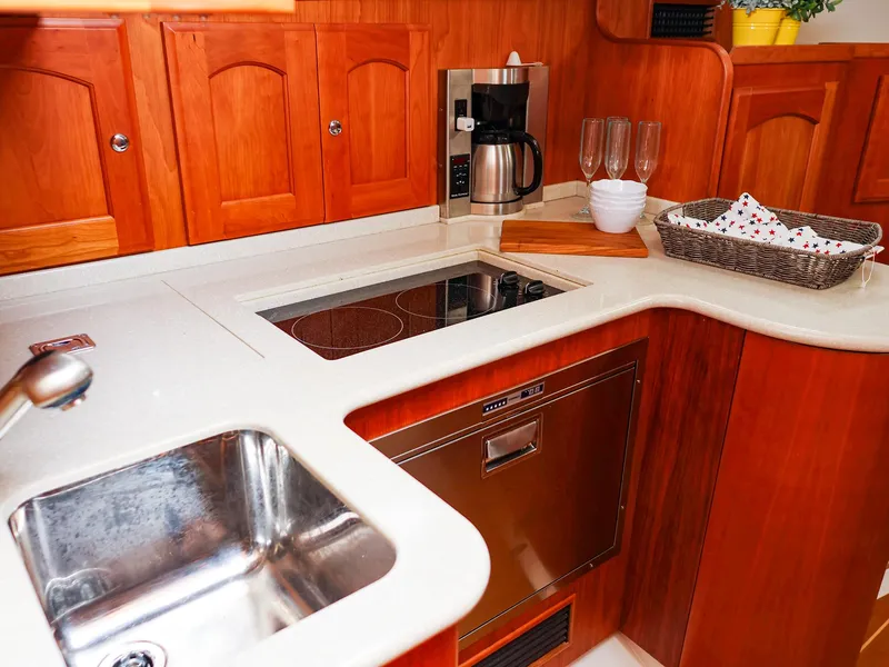 Slide: The Image of Luxurious 2009 Legacy 32 yacht kitchen with wooden cabinets, sink, and modern appliances. - 44