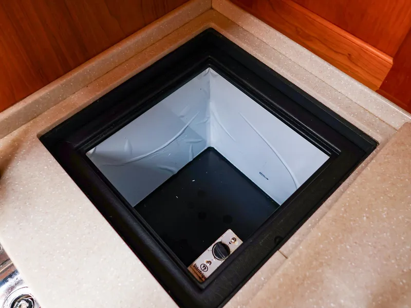 Slide: The Image of Built-in cooler compartment on a 2009 Legacy 32 boat, featuring a sleek countertop design. - 48