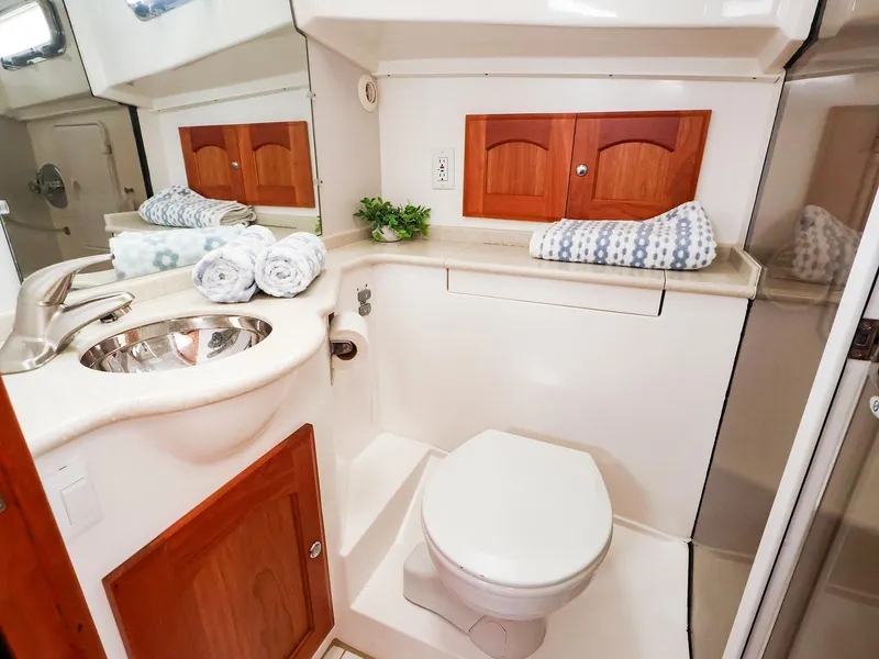 Slide: The Image of Compact boat bathroom with sink, toilet, and wooden cabinets in a 2009 Legacy 32 model. - 49