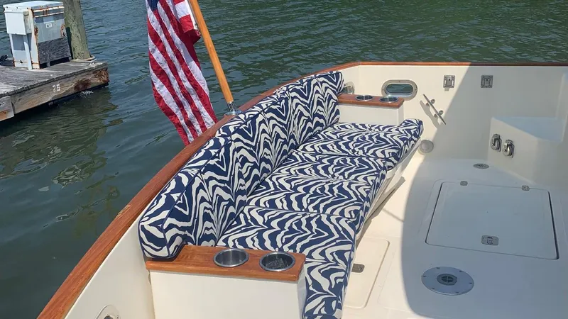 Slide: The Image of 2009 Legacy 32 boat with patterned seating and American flag at dockside. - 8