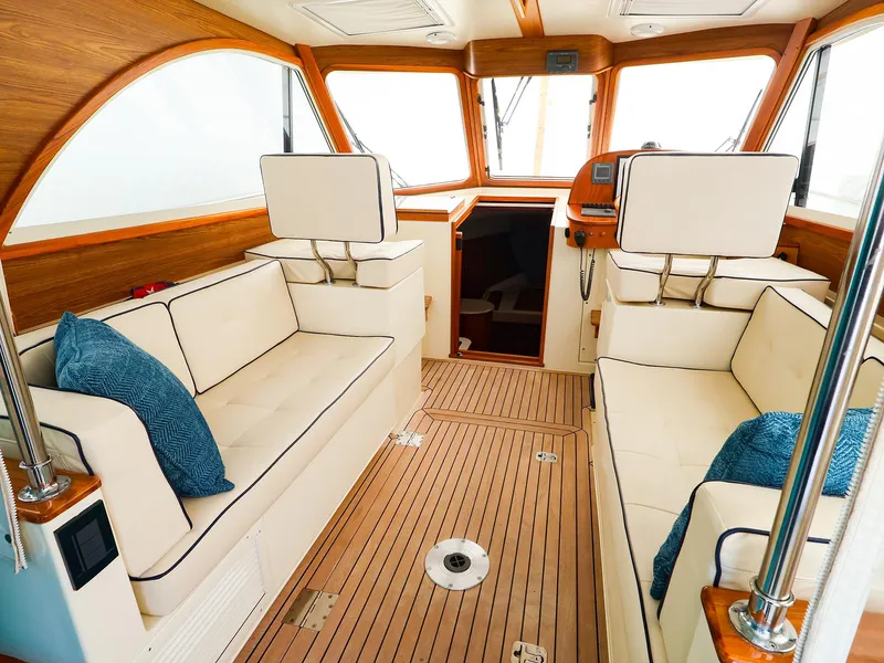 Slide: The Image of Interior of 2009 Legacy 32 boat with beige seating and wooden accents. - 9