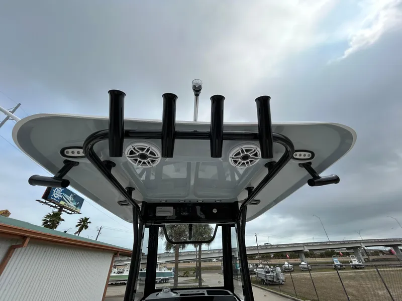 Slide: The Image of 2025 Sea Hunt Gamefish 27 T-top with rod holders and speakers, under cloudy sky. - 15