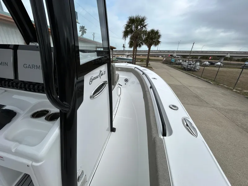 Slide: The Image of 2025 Sea Hunt Gamefish 27 boat with coffin box, docked near palm trees and highway. - 16