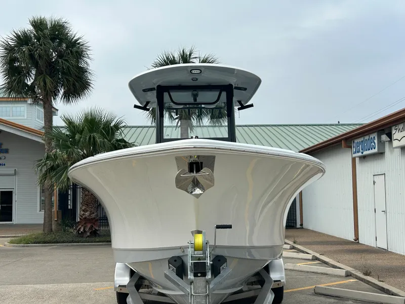 Slide: The Image of 2025 Sea Hunt Gamefish 27 boat with coffin box on trailer, parked near palm trees. - 5