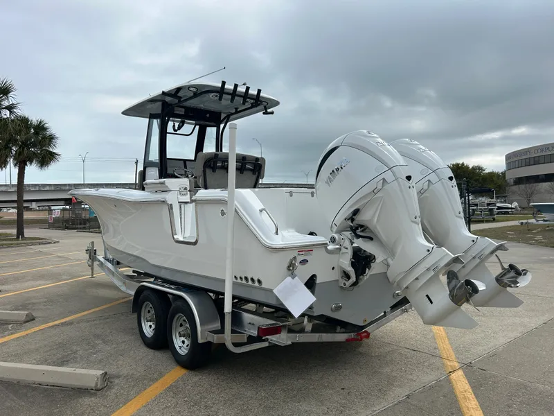 Slide: The Image of 2025 Sea Hunt Gamefish 27 with Coffin Box on trailer, featuring dual outboard engines. - 6