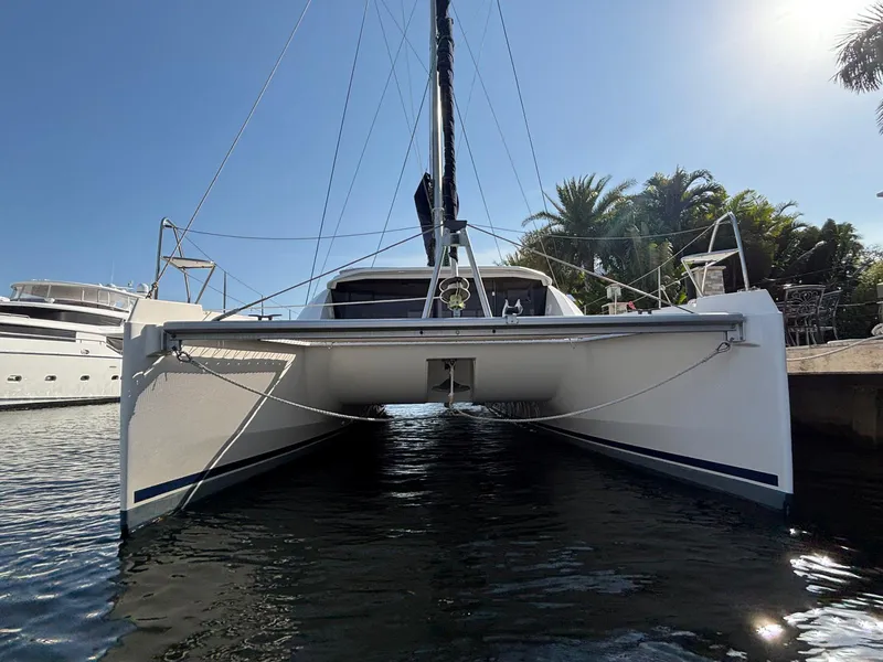 Slide: The Image of 2019 Leopard 40 catamaran docked, viewed from the front, with clear blue sky and palm trees. - 36