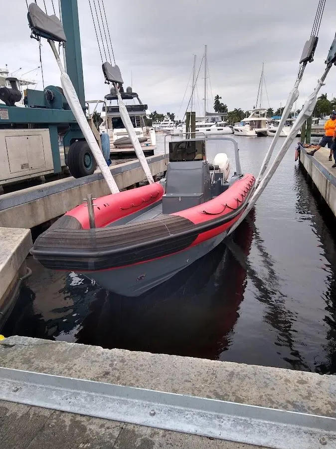 Slide: The Image of Inflatable Rigid boat, 2016 model, docked at marina with lifting straps. - 2