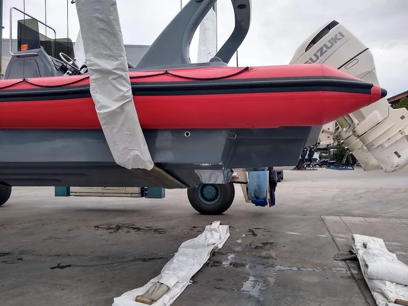 Slide: The Image of Red inflatable rigid boat with Suzuki engine, 2016 model, on a concrete surface. - 3