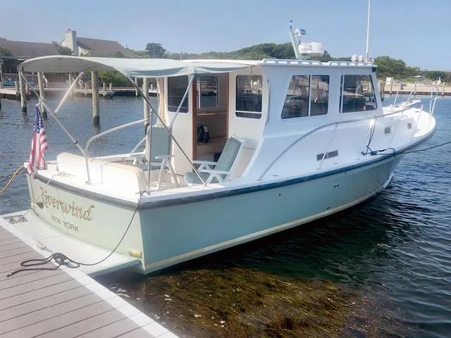 The Image of 2008 Eastern Casco Bay 31 boat docked, featuring a sleek design and American flag. - 0