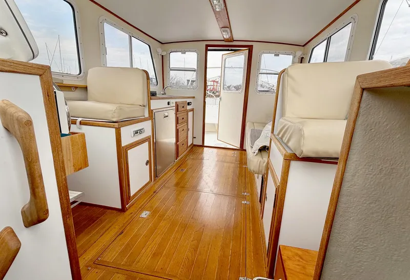 Slide: The Image of Interior of 2008 Eastern Casco Bay 31 boat with wood flooring and beige seating. - 10