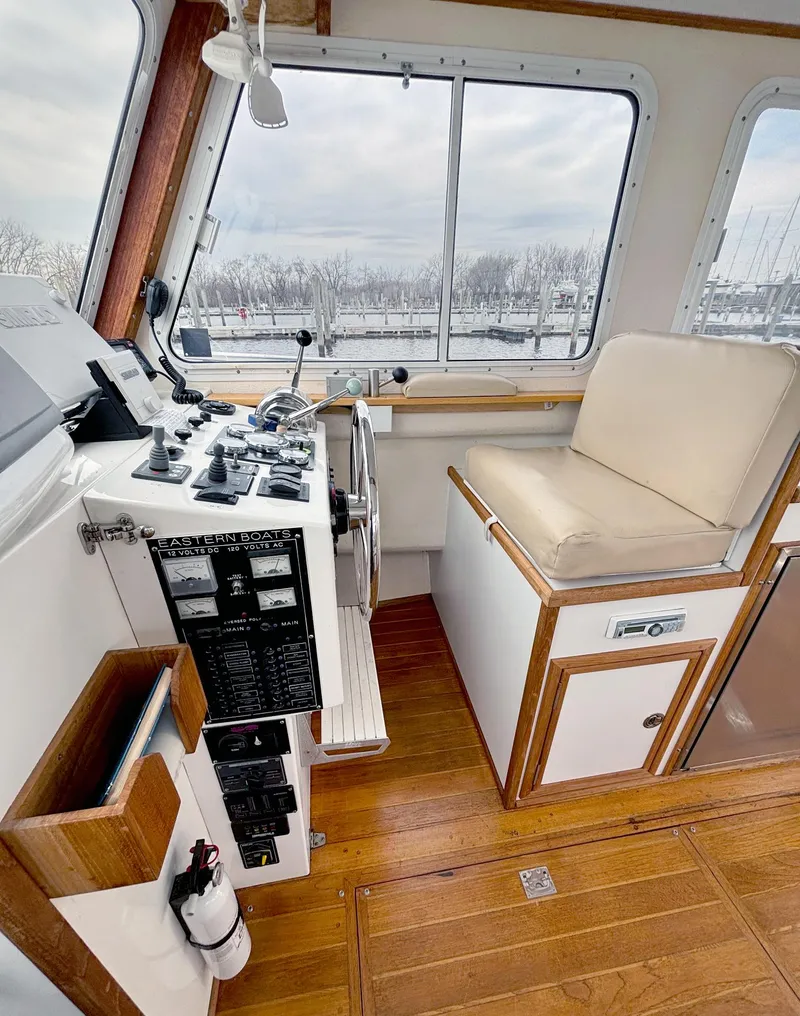 Slide: The Image of 2008 Eastern Casco Bay 31 boat interior with helm, controls, and cushioned seating. - 14