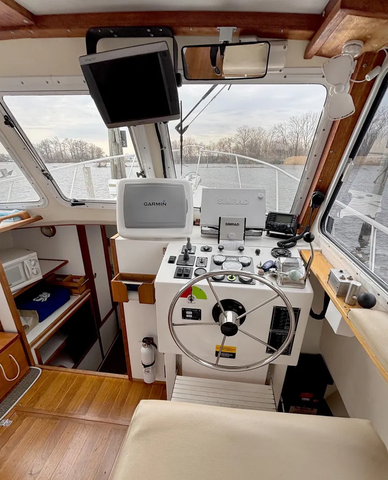 Slide: The Image of 2008 Eastern Casco Bay 31 boat cockpit with steering wheel and navigation equipment. - 16