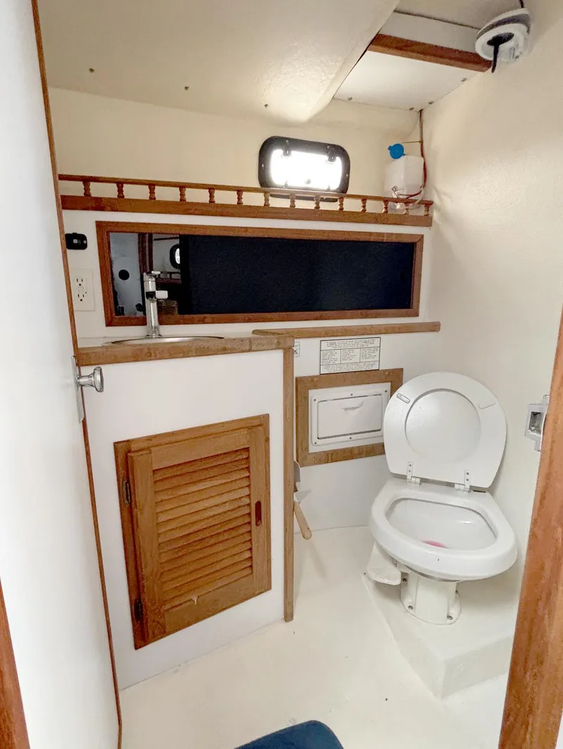 Slide: The Image of 2008 Eastern Casco Bay 31 boat bathroom with toilet and wooden cabinetry. - 19