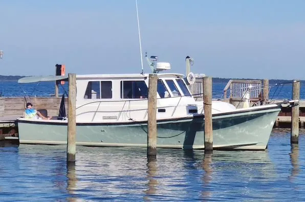 Slide: The Image of 2008 Eastern Casco Bay 31 boat docked at a marina on a sunny day. - 2