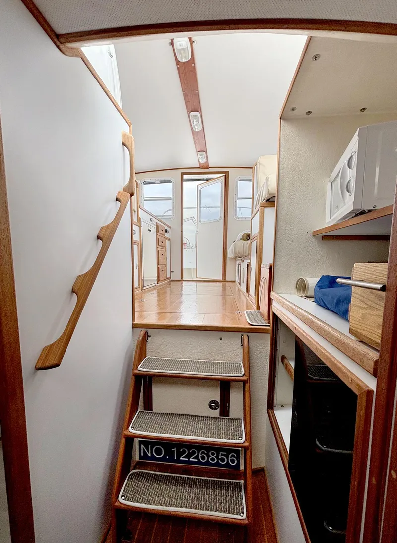 Slide: The Image of Interior of 2008 Eastern Casco Bay 31 boat, featuring wooden stairs and compact kitchen area. - 20