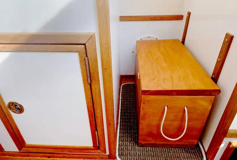Slide: The Image of 2008 Eastern Casco Bay 31 interior with wooden storage bench and cabinet. - 23