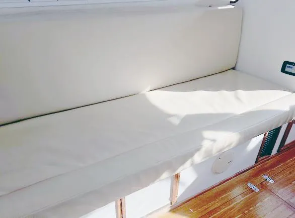 Slide: The Image of 2008 Eastern Casco Bay 31 boat interior with beige cushioned seating and wooden flooring. - 24