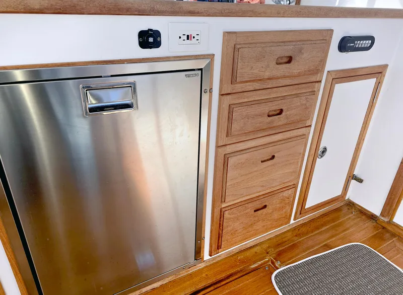 Slide: The Image of 2008 Eastern Casco Bay 31 interior with stainless steel fridge and wooden cabinetry. - 27