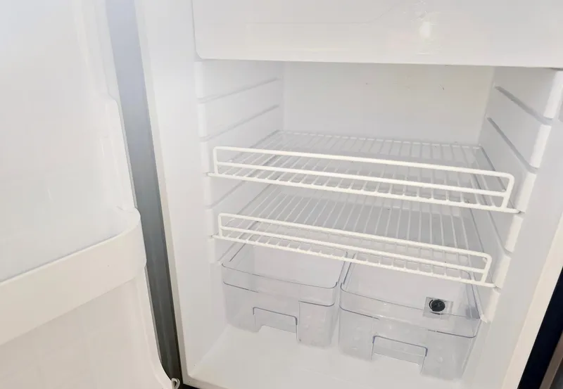 Slide: The Image of Empty refrigerator interior with wire shelves and drawers, part of a 2008 Eastern Casco Bay 31. - 28