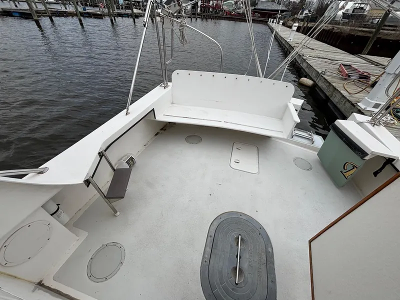 Slide: The Image of 2008 Eastern Casco Bay 31 boat deck with seating, docked by the water. - 6