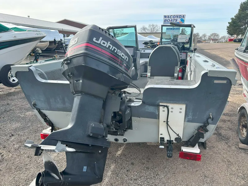 Slide: The Image of 1996 Lund 1700 Pro Sport Adventure boat with Johnson outboard motor, displayed at a dealership. - 4