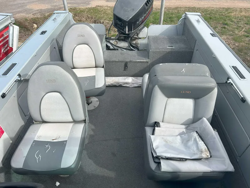 Slide: The Image of 1996 Lund 1700 Pro Sport Adventure boat interior with seating and motor. - 7