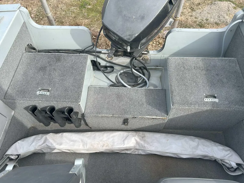Slide: The Image of 1996 Lund 1700 Pro Sport Adventure boat interior with motor and storage compartments. - 8