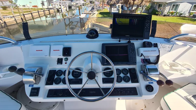 Slide: The Image of 1999 Mainship 350 Trawler helm with steering wheel, controls, and navigation equipment. - 10