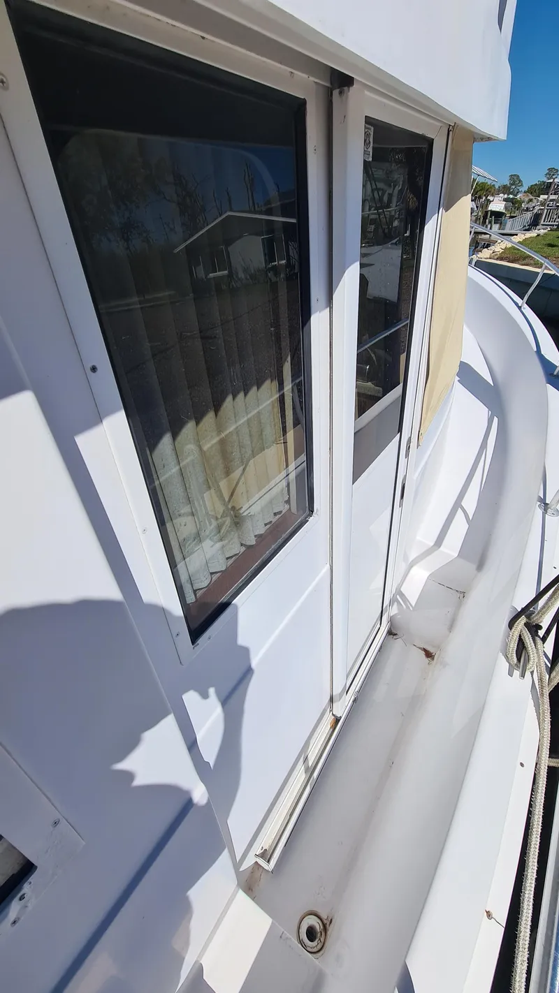 Slide: The Image of 1999 Mainship 350 Trawler exterior view with windows and railing. - 14