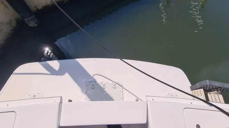Slide: The Image of 1999 Mainship 350 Trawler docked, view of stern and water reflection. - 16