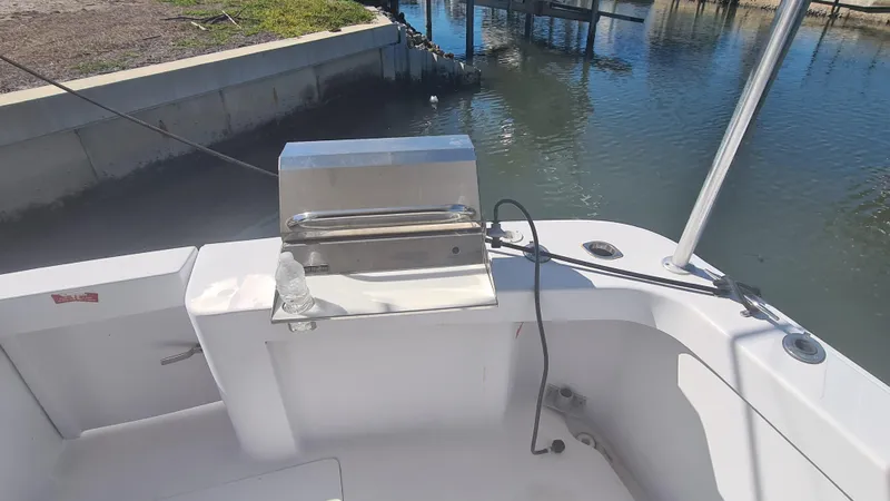 Slide: The Image of 1999 Mainship 350 Trawler deck with stainless steel grill by the water. - 17