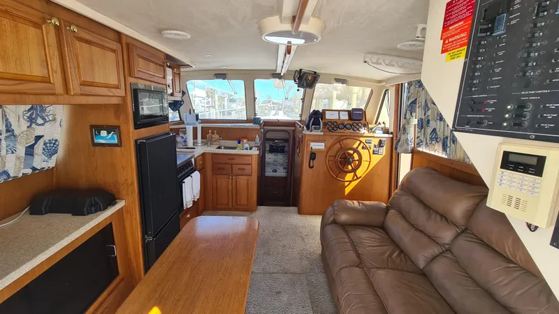 Slide: The Image of Interior of 1999 Mainship 350 Trawler with wood cabinetry and leather seating. - 18