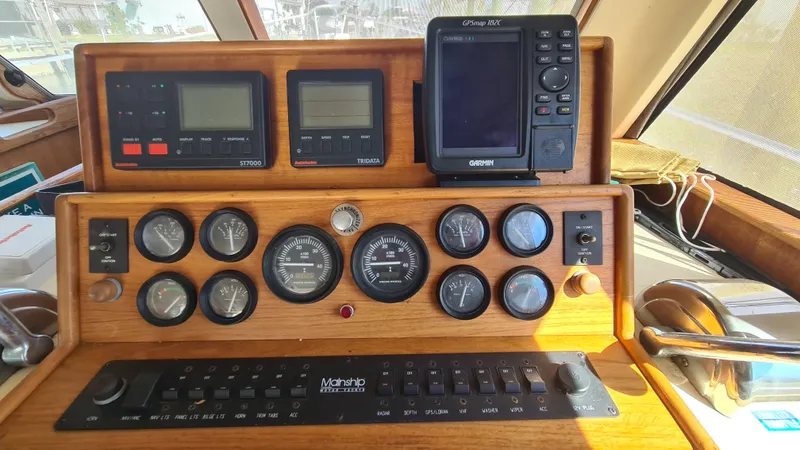 Slide: The Image of 1999 Mainship 350 Trawler dashboard with gauges and navigation equipment. - 21