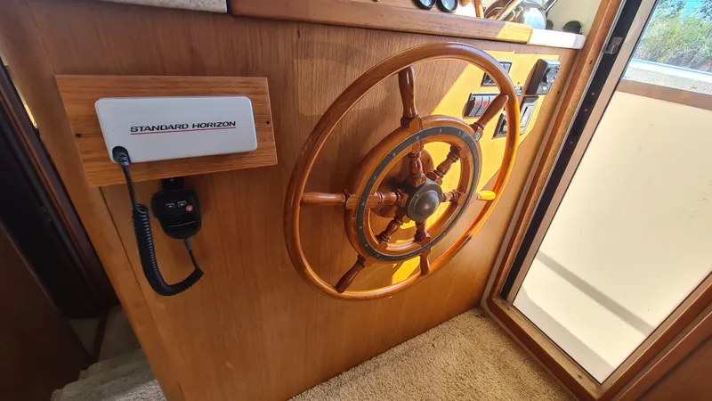 Slide: The Image of 1999 Mainship 350 Trawler helm with wooden wheel and Standard Horizon radio. - 22