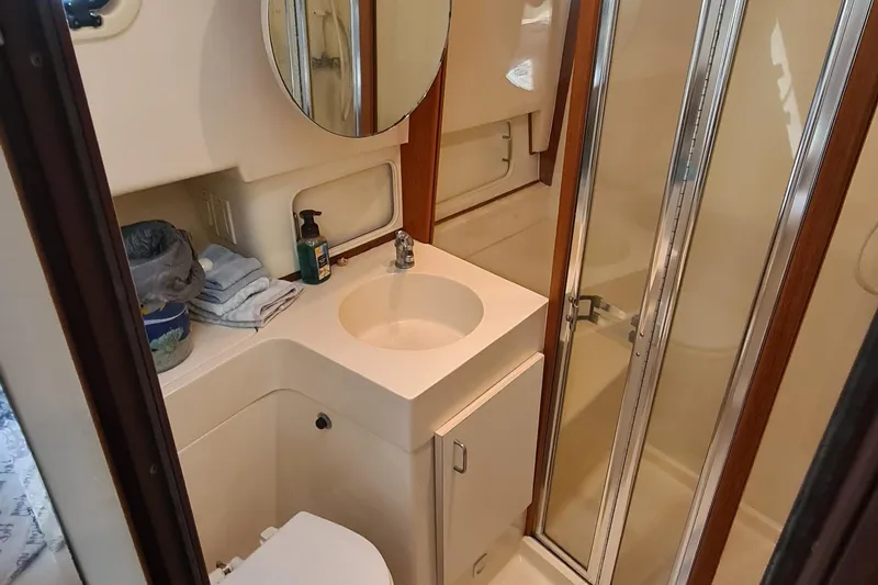 Slide: The Image of Bathroom interior of 1999 Mainship 350 Trawler with sink, mirror, and shower. - 24