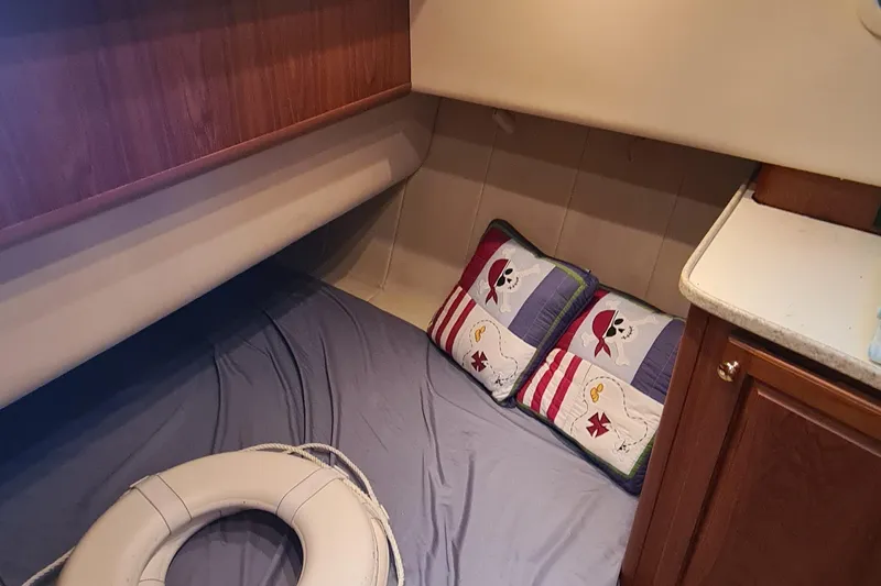 Slide: The Image of Cozy cabin interior of 1999 Mainship 350 Trawler with nautical-themed pillows and life preserver. - 25