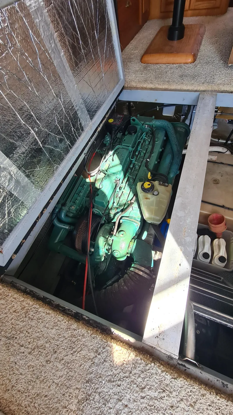 Slide: The Image of Engine compartment of a 1999 Mainship 350 Trawler, showcasing the engine and surrounding components. - 27