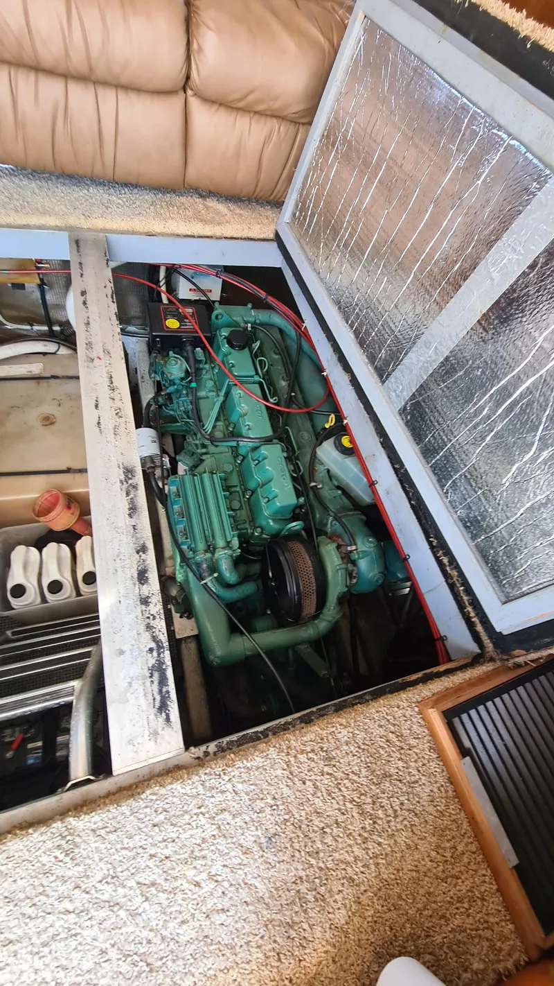 Slide: The Image of Engine compartment of a 1999 Mainship 350 Trawler, showcasing the engine and surrounding components. - 28