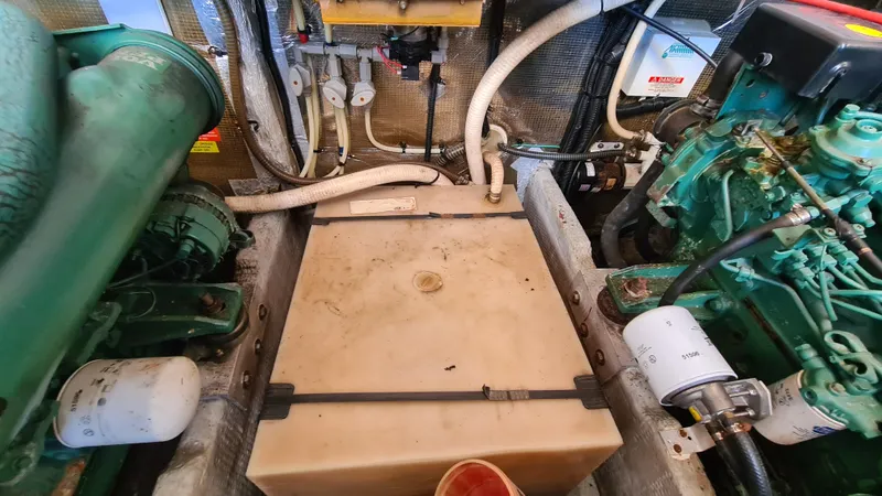 Slide: The Image of Engine room of a 1999 Mainship 350 Trawler with visible components and hoses. - 29