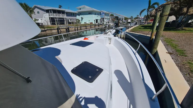 Slide: The Image of 1999 Mainship 350 Trawler docked in a sunny residential canal setting. - 4