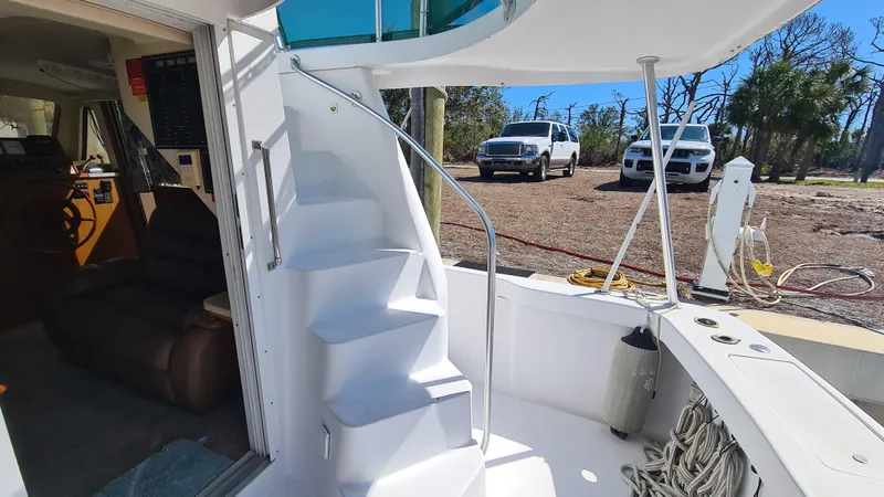 Slide: The Image of 1999 Mainship 350 Trawler with white spiral staircase and outdoor seating area. - 7