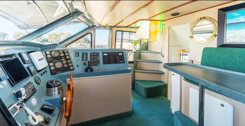 Slide: The Image of Luxurious 1994 Shaw 57 yacht interior with helm, seating, and staircase. - 11