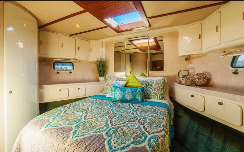 Slide: The Image of Luxurious 1994 Shaw 57 yacht bedroom with elegant bedding and ample storage. - 12