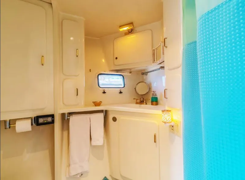 Slide: The Image of Compact 1994 Shaw 57 bathroom with white cabinetry and blue shower curtain. - 13