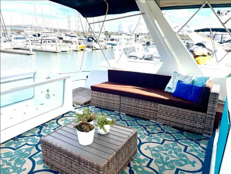 Slide: The Image of Luxurious Shaw 57 yacht deck with wicker furniture, potted plants, and marina view, 1994 model. - 17