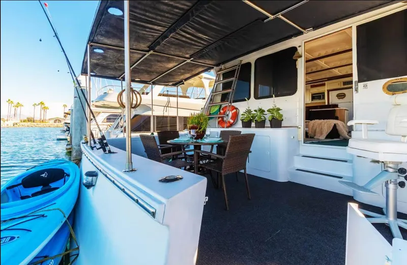 Slide: The Image of Luxurious 1994 Shaw 57 yacht with outdoor dining, kayak, and scenic marina view. - 2