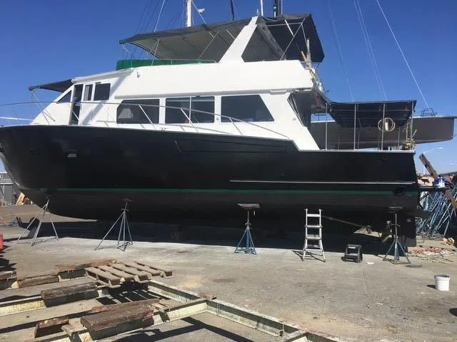 Slide: The Image of Large 1994 Shaw 57 yacht on dry dock for maintenance under clear blue sky. - 20