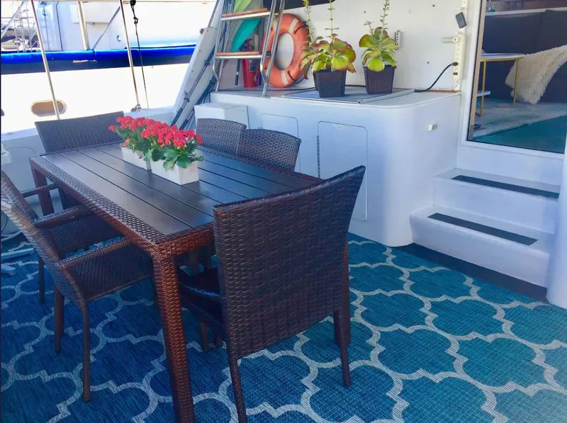 Slide: The Image of Outdoor dining area on Shaw 57 yacht, featuring wicker chairs and floral centerpiece, 1994 model. - 3