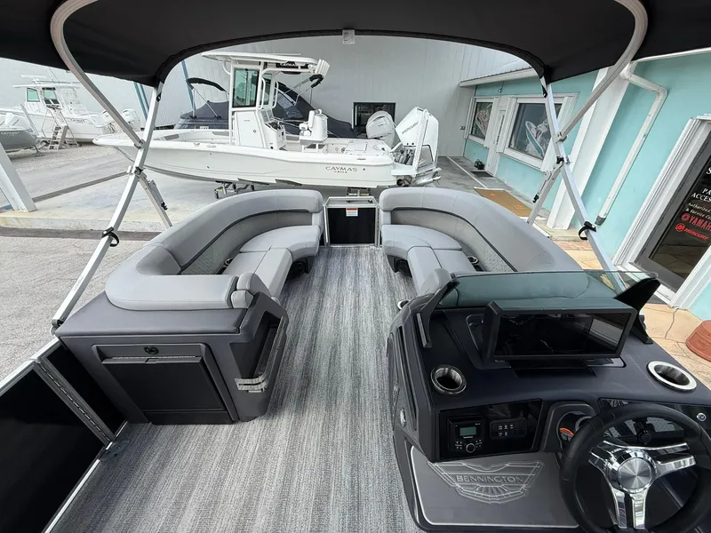 Slide: The Image of 2025 Bennington 22 MFB pontoon boat interior with gray seating and modern dashboard. - 16