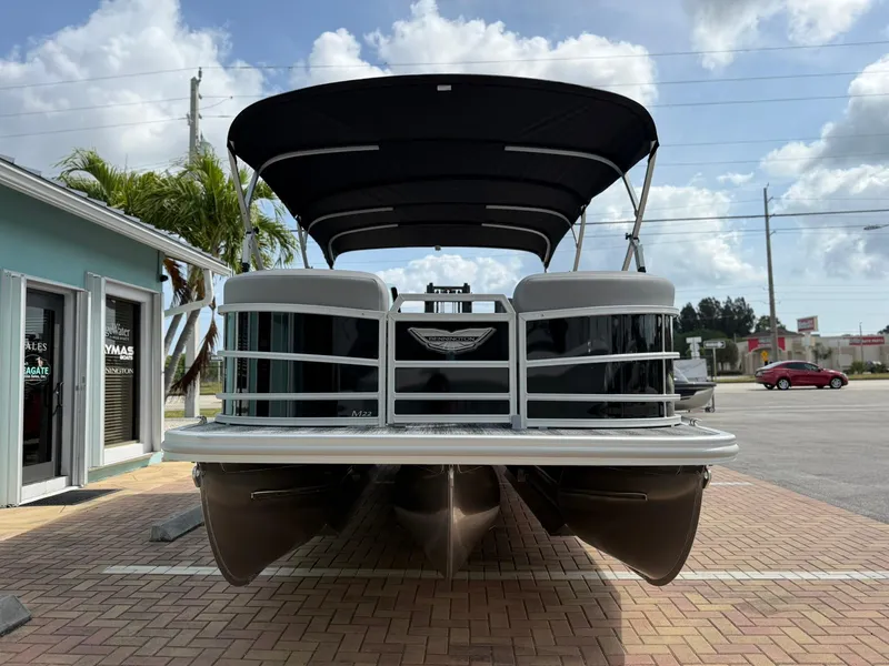 Slide: The Image of 2025 Bennington 22 MFB pontoon boat with canopy, parked on brick pavement. - 2